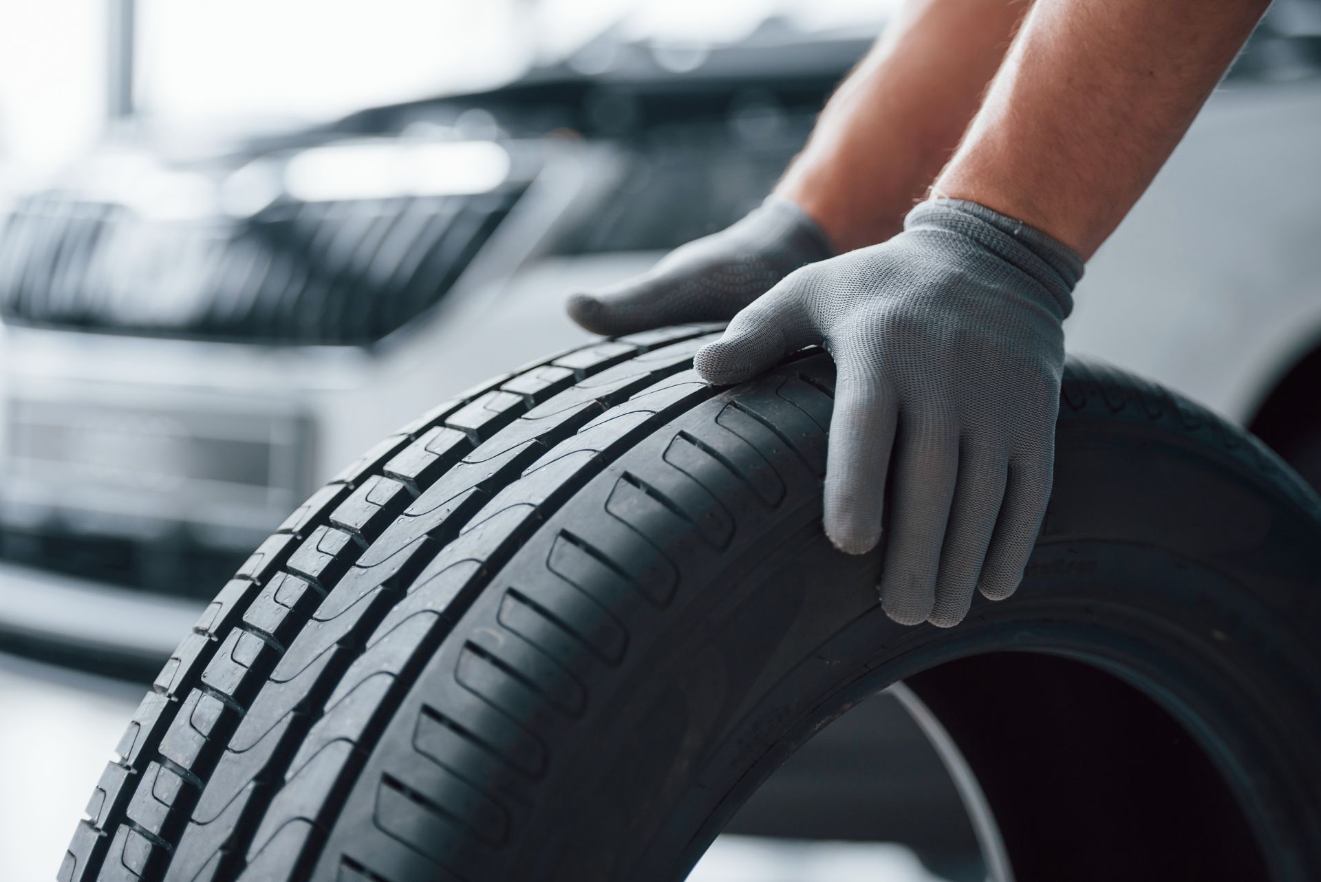 hands-only-mechanic-holding-tire-repair-garage-replacement-winter-summer-tires
